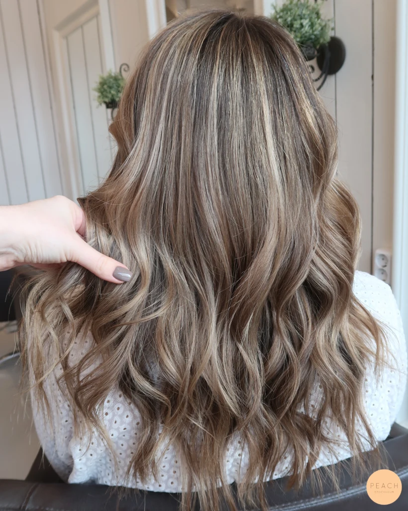 Beige blond hårfärg med ljusa slingor och rootshadow och mjuka teasylights
