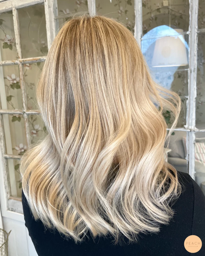 Creamy blonde hair med ljusa slingor