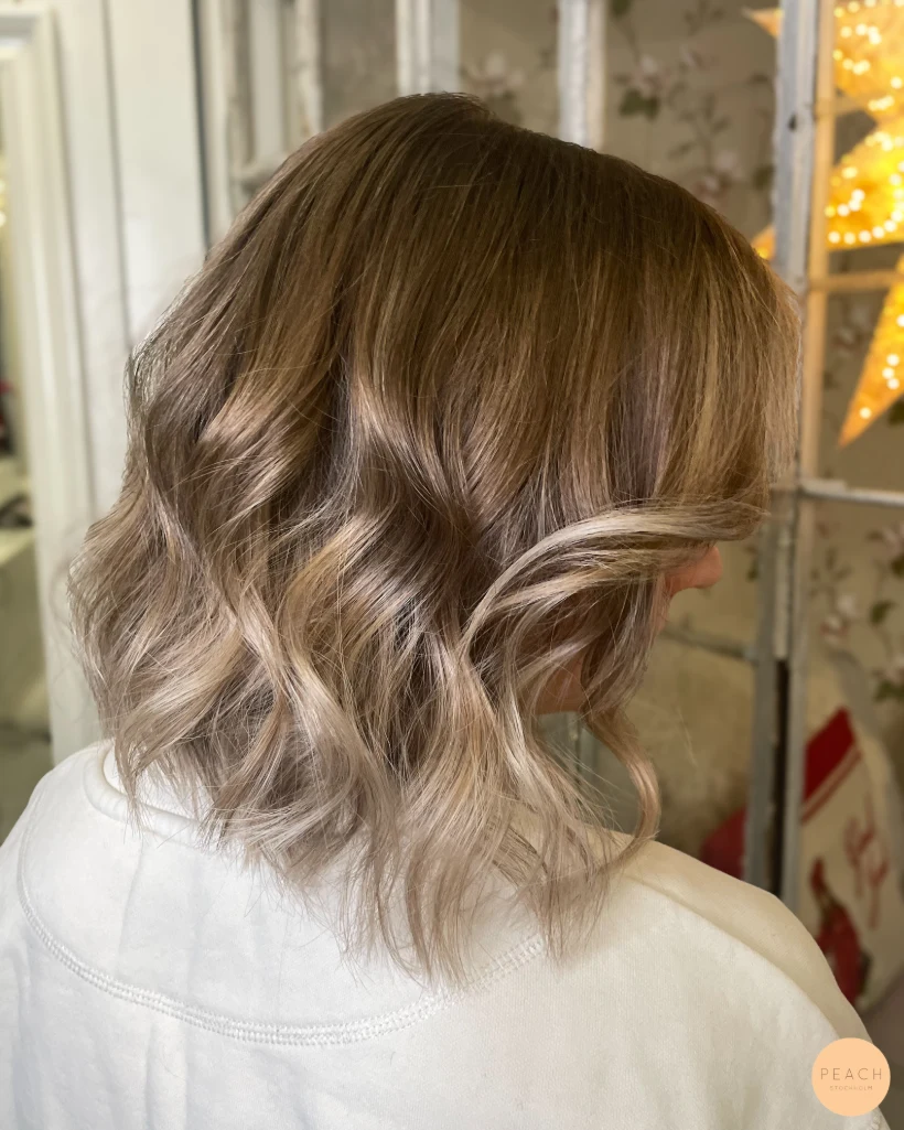 Balayage i mörkt hår med ljusa slingor