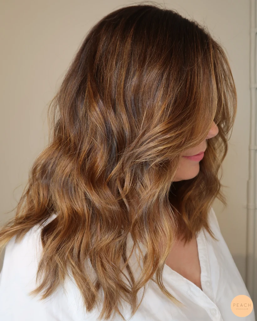Balayage i brunt hår, varm hårfärg med toner av kanel och honung