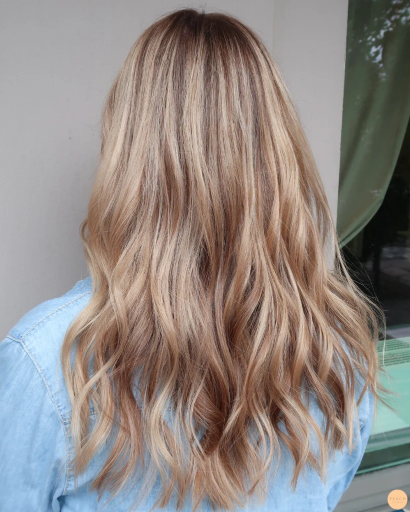 Beigeblond hårfärg med ljusa slingor och rootshadow