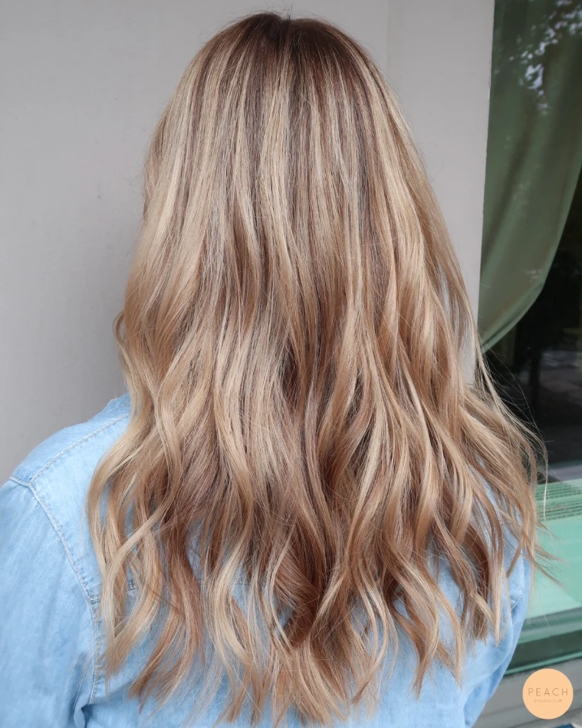 Beigeblond hårfärg med ljusa slingor och rootshadow