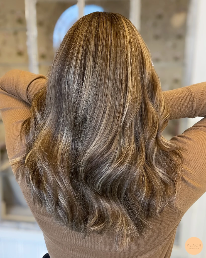 Slingor i ett ofärgat hår med beige toner