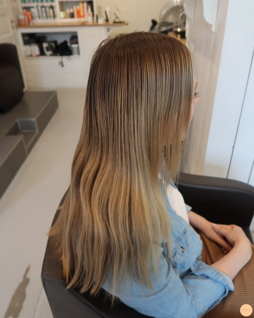Beigeblond hårfärg med ljusa slingor och rootshadow