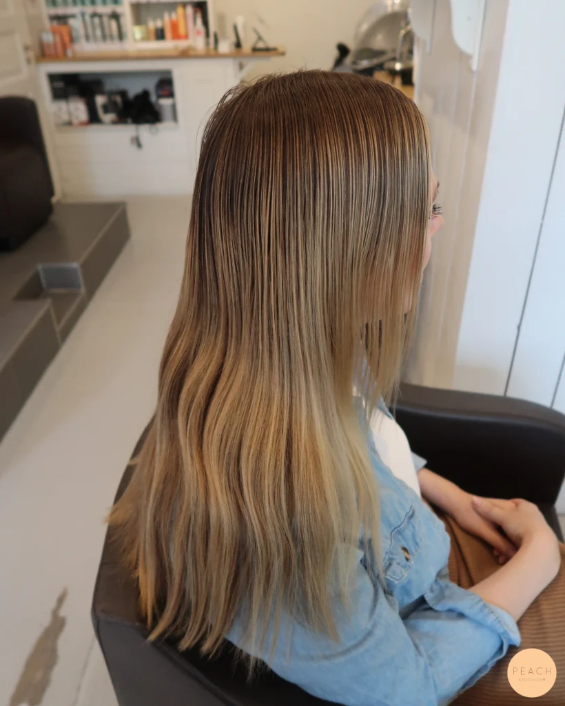 Beigeblond hårfärg med ljusa slingor och rootshadow