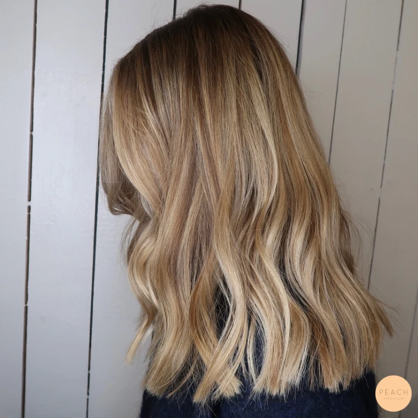 Blond hårfärg med olika nyanser och ljusa slingor