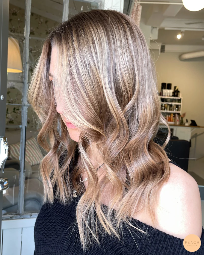 Mellanblond hårfärg med ljusa slingor och mjuk root shadow