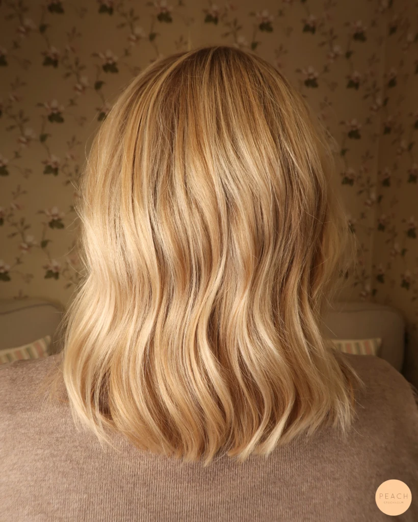 Guldblond hårfärg med ljusa slingor och mjuk root shadow