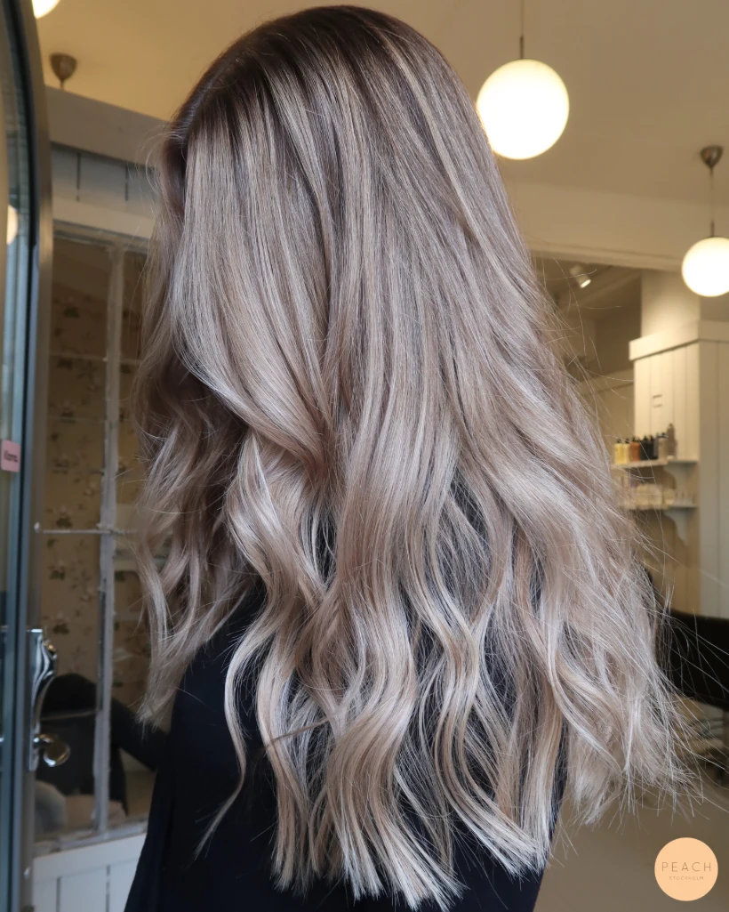 Kall blond hårfärg med ljusa slingor och mjuk utväxt