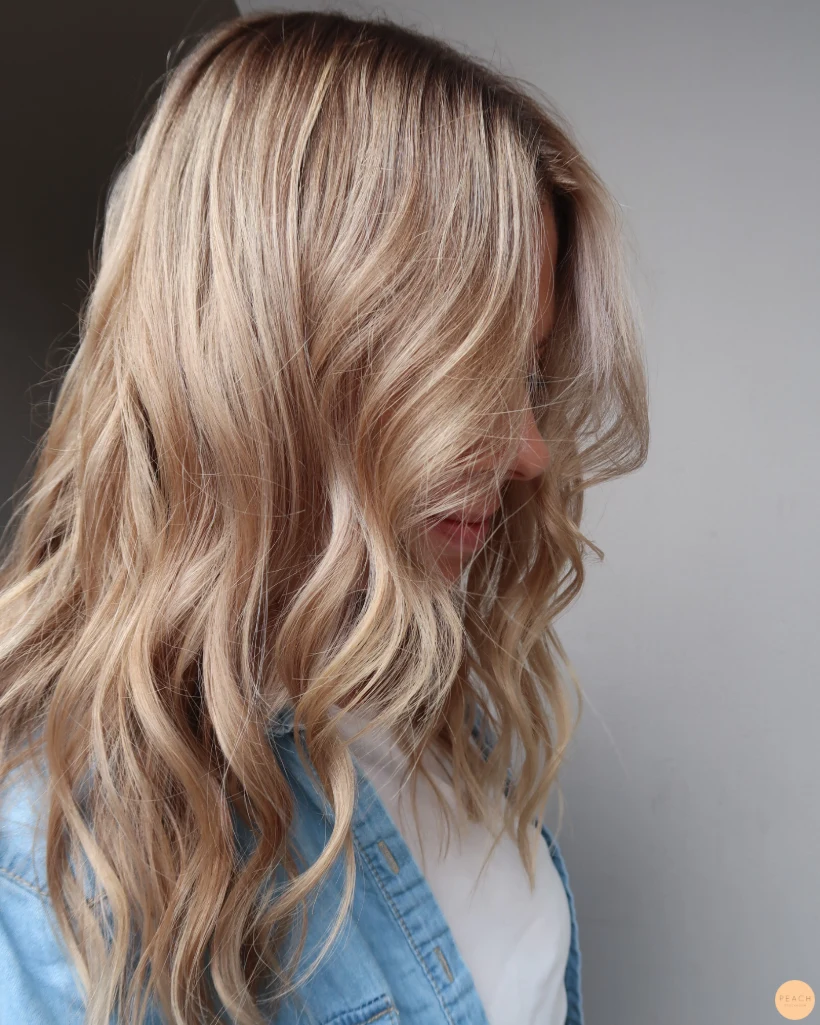 Beigeblond hårfärg med ljusa slingor och rootshadow