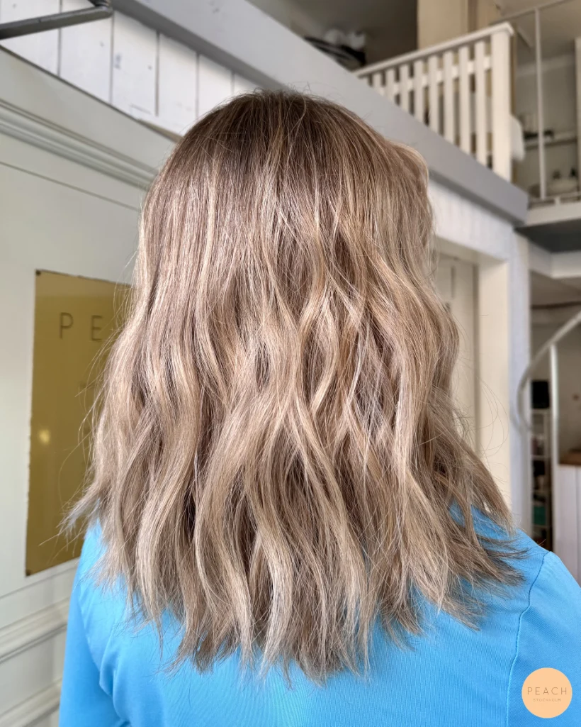 Kall beige blond hårfärg med ljusa slingor och bevarad naturlig botten