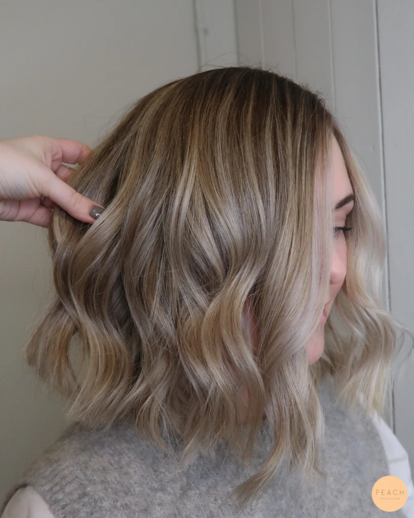 Kall blond hårfärg med ljusa slingor och rootshadow och mjuka teasylights