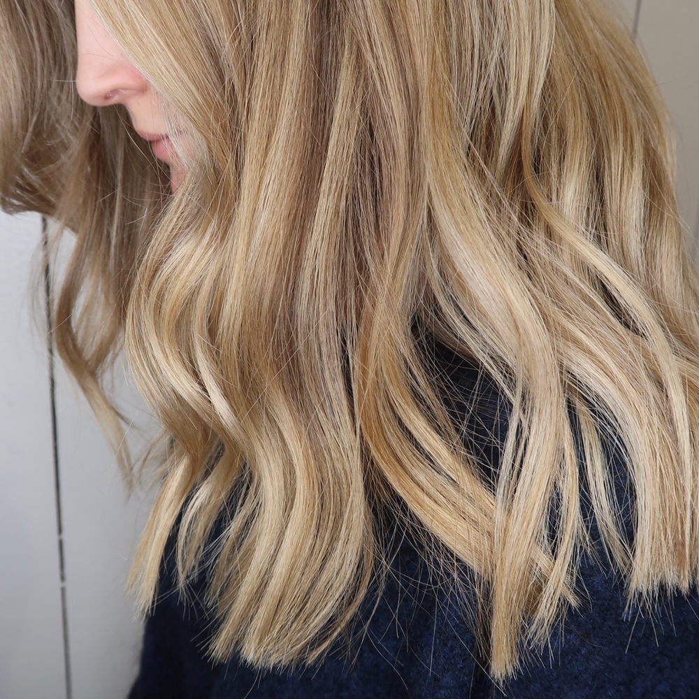 Blond hårfärg med olika nyanser och ljusa slingor