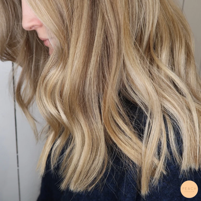 Blond hårfärg med olika nyanser och ljusa slingor
