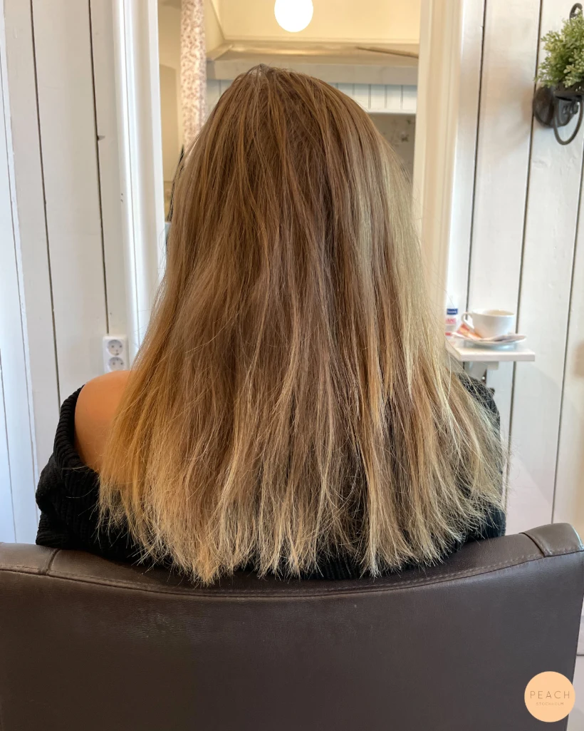 Mellanblond hårfärg med ljusa slingor och mjuk root shadow