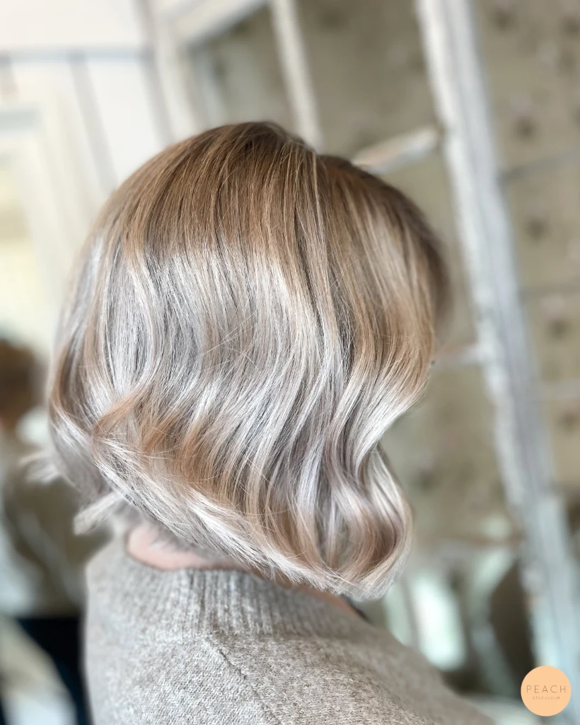 Kall blond hårfärg med ljusa slingor och mjuk root shadow