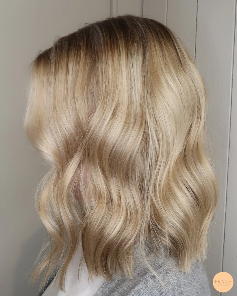 Lyxig blond hårfärg med slingor och lob klippning