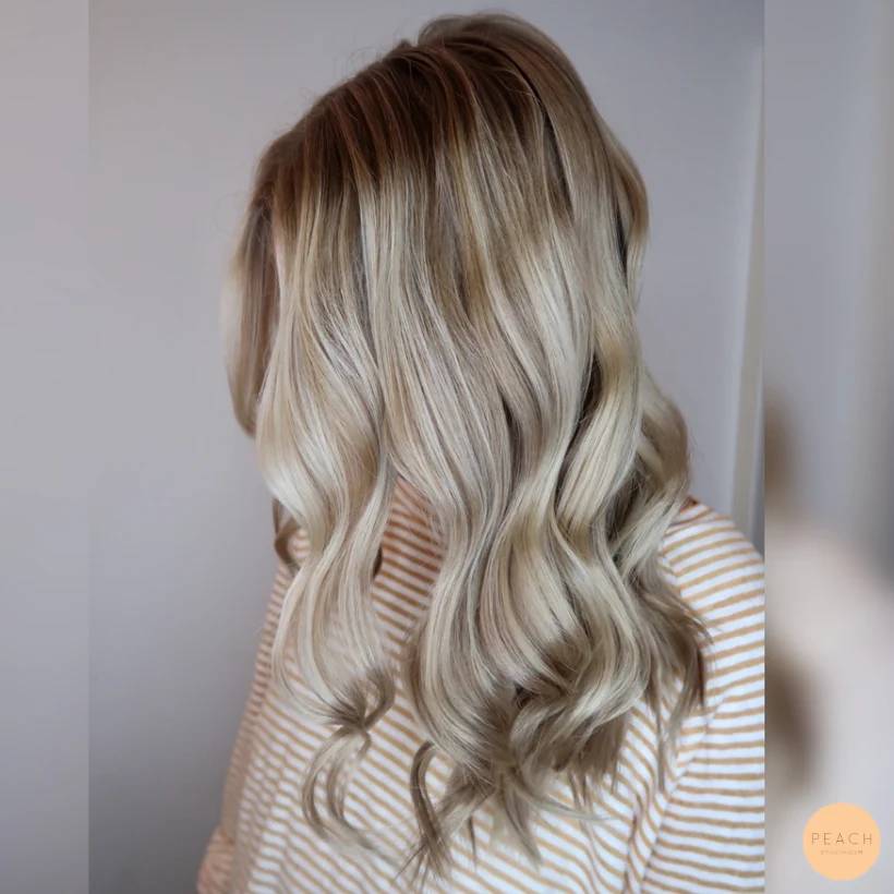 Kall beigeblond hårfärg med slingor och lockar