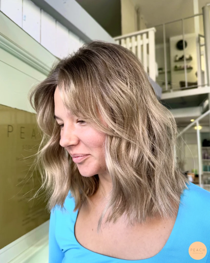 Kall beige blond hårfärg med ljusa slingor och bevarad naturlig botten