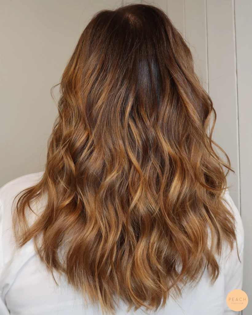 Balayage i brunt hår, varm hårfärg med toner av kanel och honung