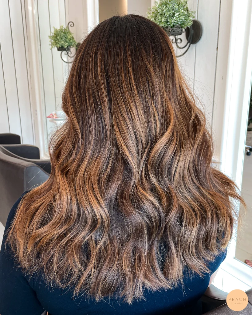 Karamellbalayage med varma slingor i brunt hår