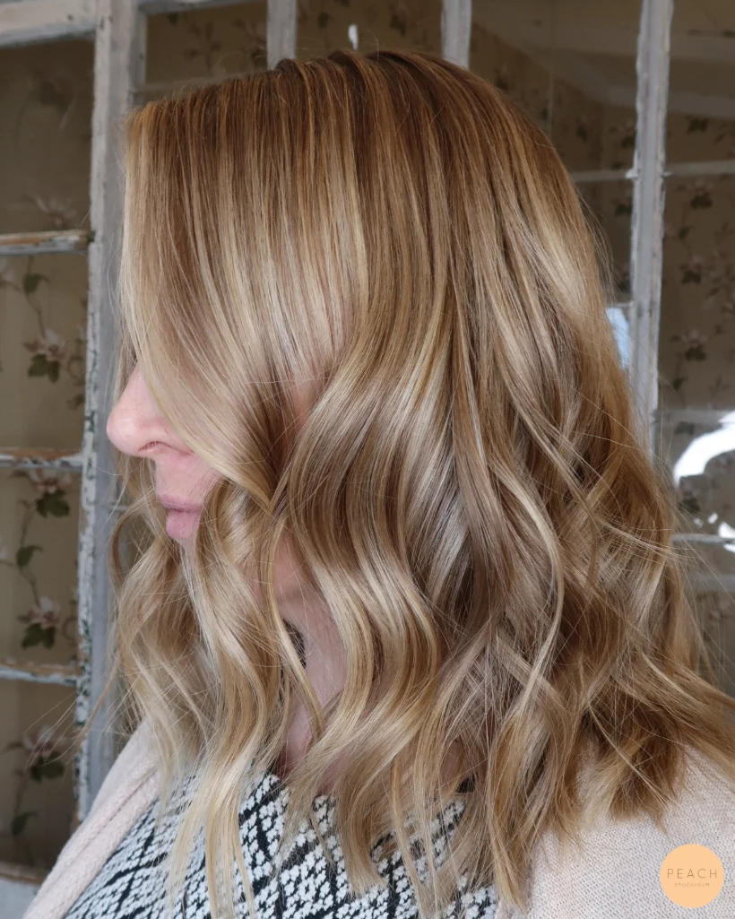 Mellanblond hårfärg med ljusa slingor och beige toner