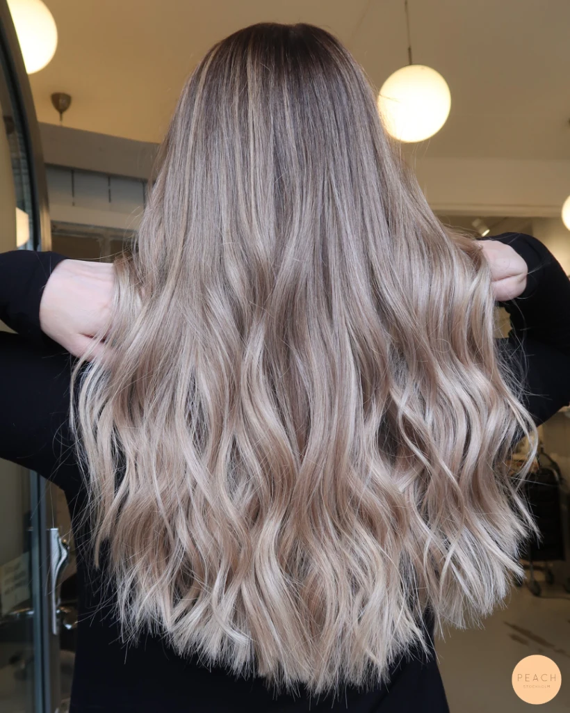 Kall blond hårfärg med ljusa slingor och mjuk utväxt