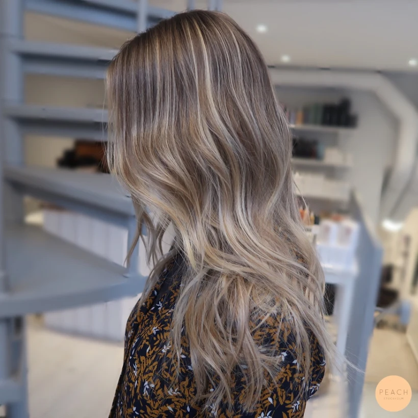 Varm blond balayage med mjuka lockar