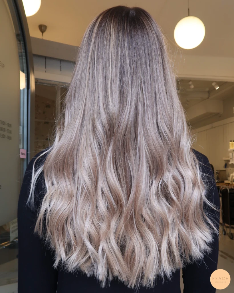 Kall blond hårfärg med ljusa slingor och mjuk utväxt