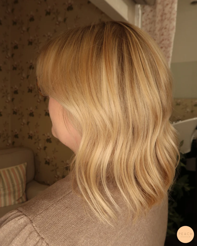 Guldblond hårfärg med ljusa slingor och mjuk root shadow