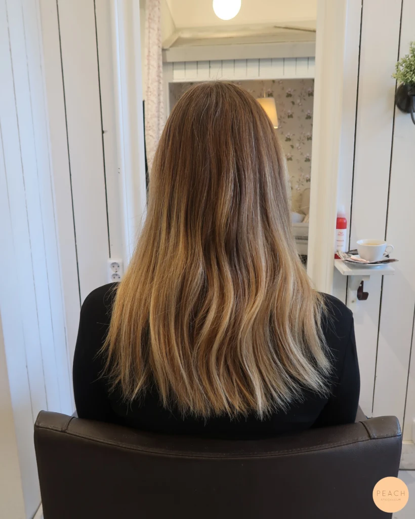 Guldblond hårfärg med slingor och ljusa slingor och gyllene toner