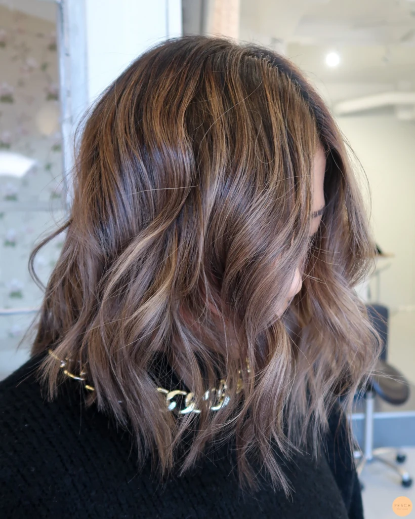Bronde lob med ljusa slingor i mörkt hår