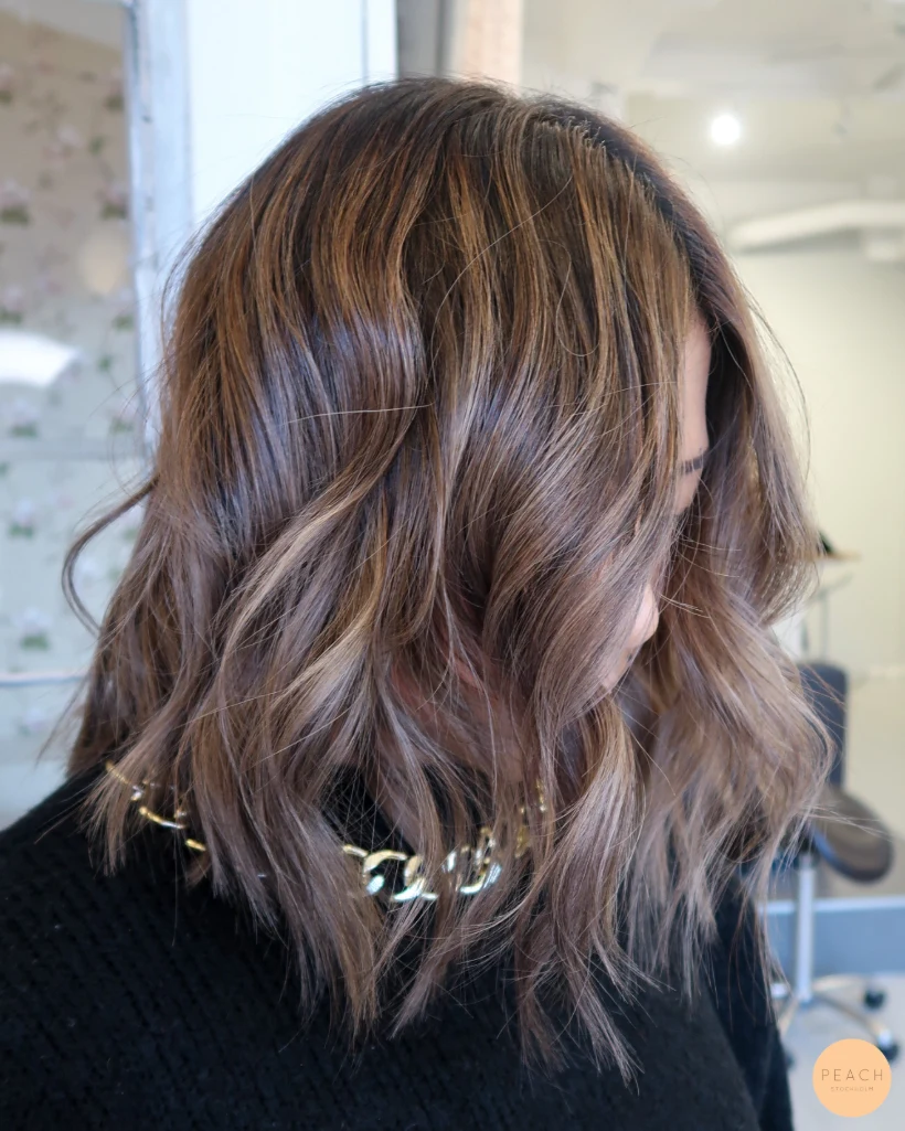 Bronde lob med ljusa slingor i mörkt hår