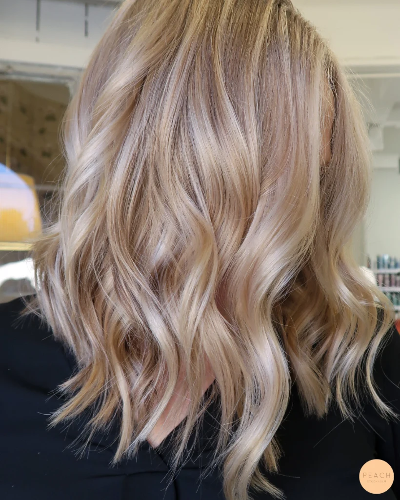 Beige blond hårfärg med ljusa slingor och lowlights och mjuk root shadow
