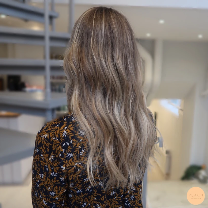 Varm blond balayage med mjuka lockar